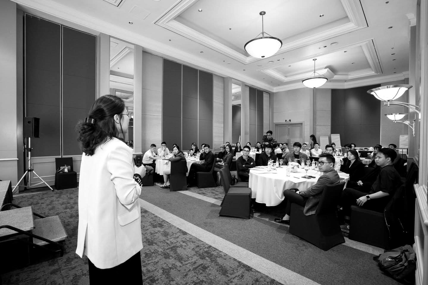 Trương Quỳnh Phương speaking to a full room